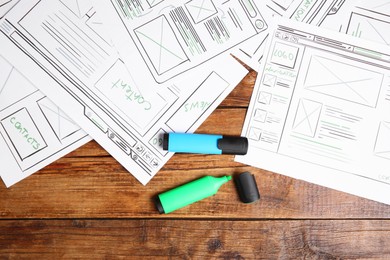 Developing UI design. Sketches of website wireframes and felt pens on wooden table, top view