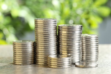 Photo of Salary concept. Stacked coins on grey table against blurred background