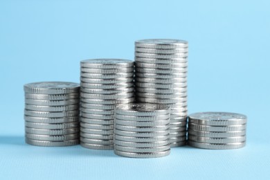 Photo of Salary concept. Stacked coins on light blue background