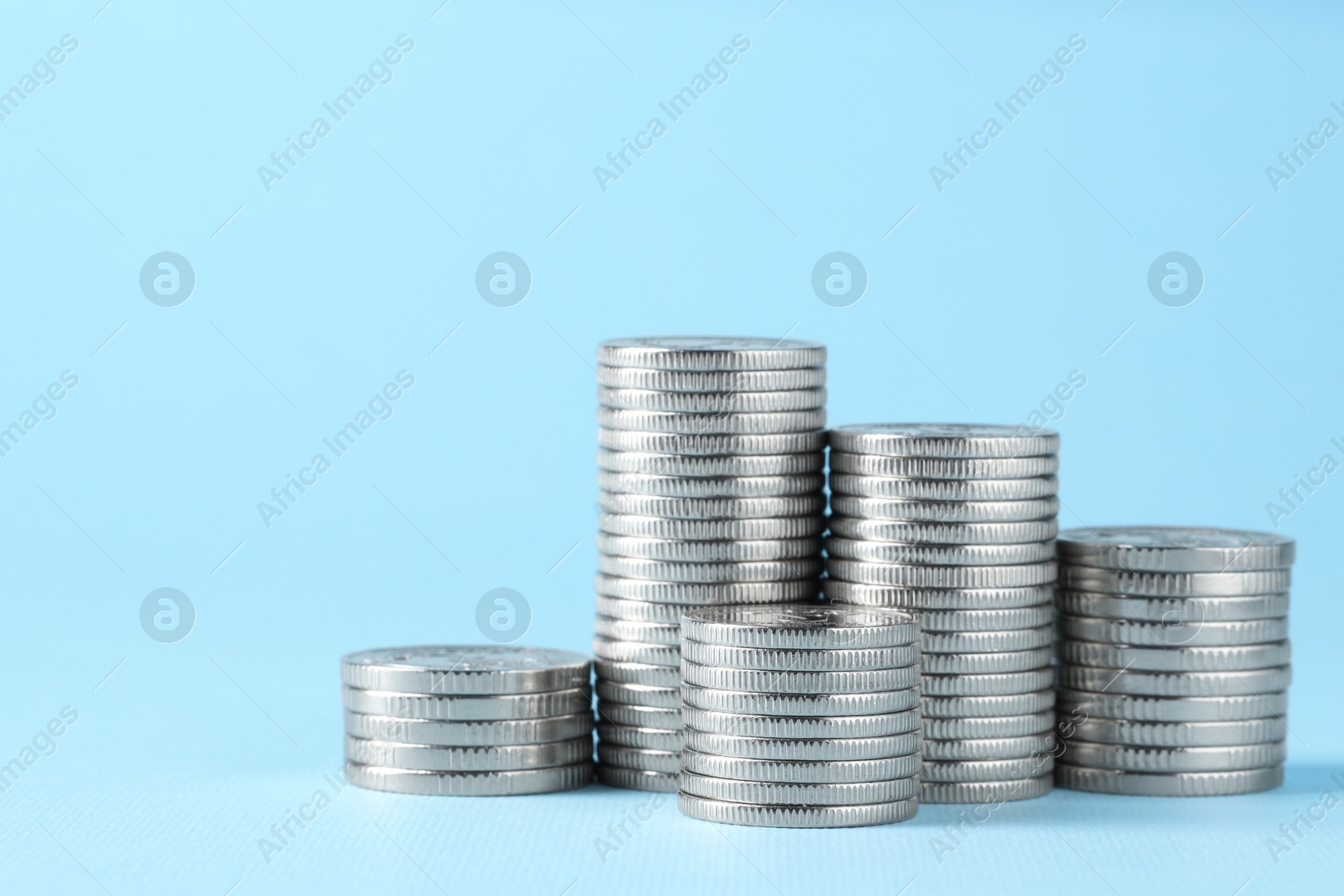 Photo of Salary concept. Stacked coins on light blue background, space for text