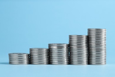 Photo of Salary concept. Stacked coins on light blue background