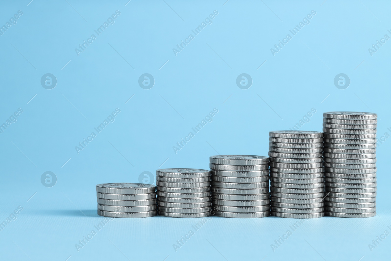 Photo of Salary concept. Stacked coins on light blue background, space for text