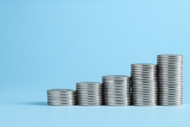 Photo of Salary concept. Stacked coins on light blue background, space for text