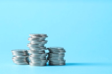 Photo of Salary concept. Stacked coins on light blue background, space for text