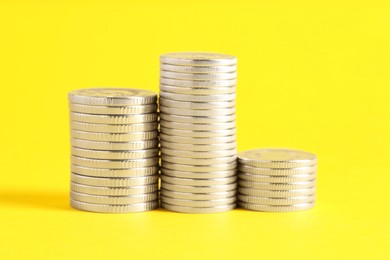 Photo of Salary concept. Stacked coins on yellow background