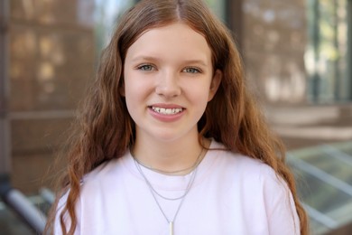 Photo of Portrait of happy teenage girl with long hair outdoors