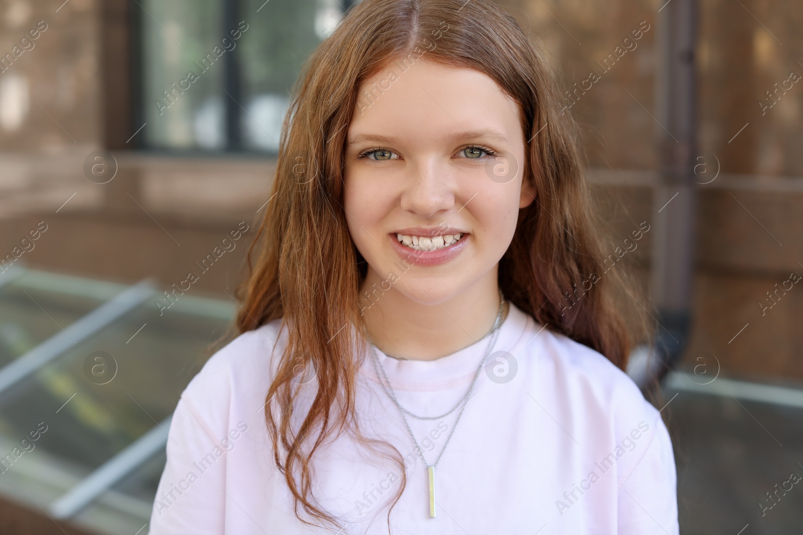 Photo of Portrait of happy teenage girl with long hair outdoors