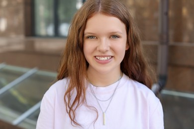 Photo of Portrait of happy teenage girl with long hair outdoors