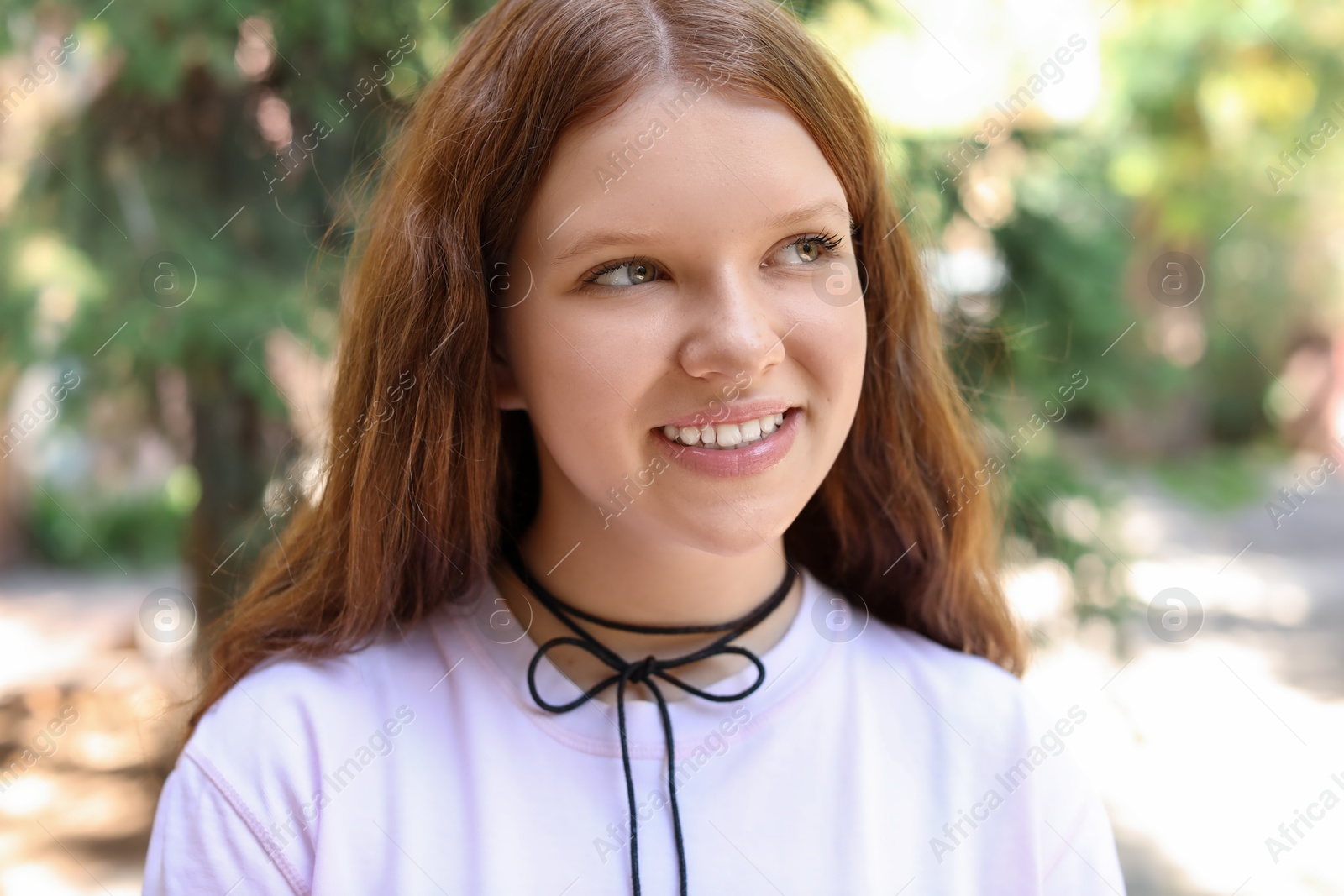 Photo of Portrait of happy teenage girl with long hair outdoors