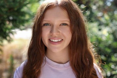 Photo of Portrait of happy teenage girl with long hair outdoors