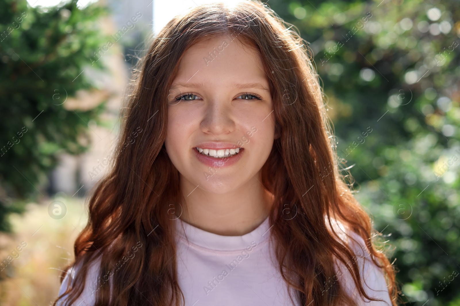 Photo of Portrait of happy teenage girl with long hair outdoors