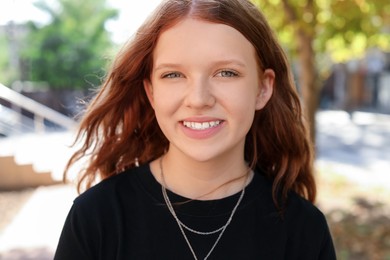 Photo of Portrait of happy teenage girl with long hair outdoors