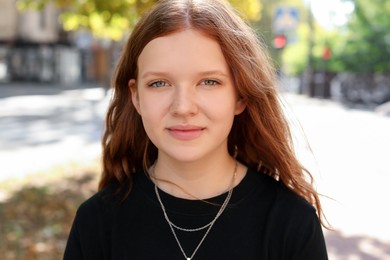 Photo of Portrait of happy teenage girl with long hair outdoors