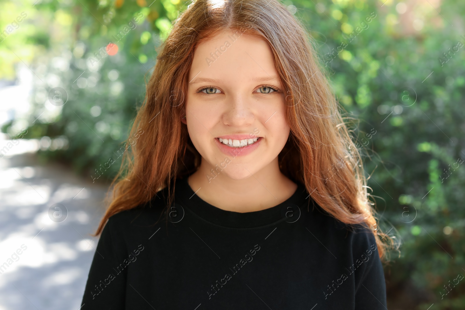 Photo of Portrait of happy teenage girl with long hair outdoors