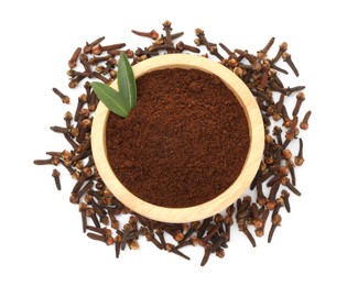 Photo of Clove powder in wooden bowl and dried buds on white background, top view. Aromatic spice