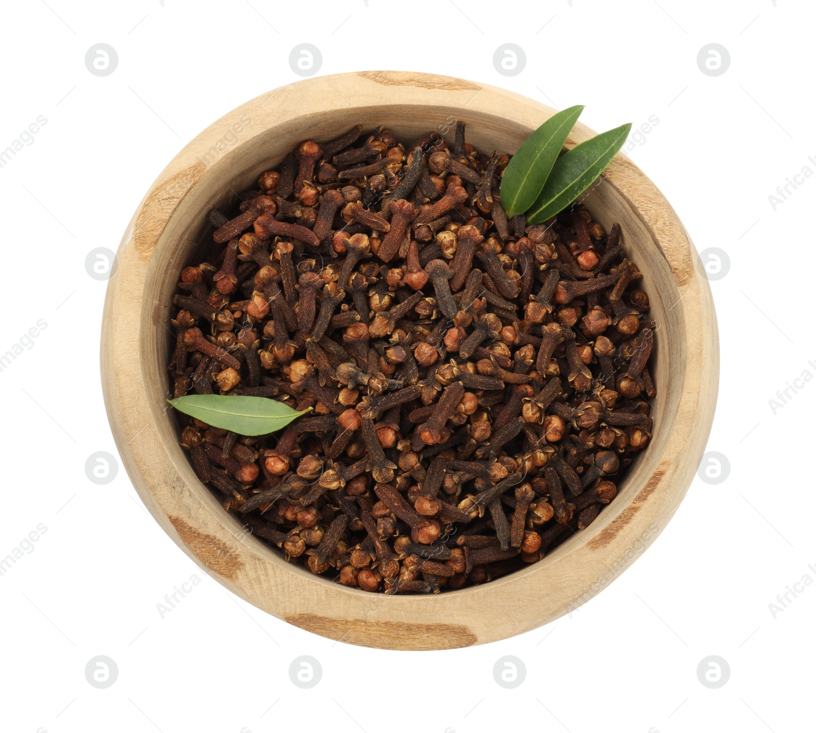 Photo of Dry clove buds and green leaves in wooden bowl on white background, top view. Aromatic spice