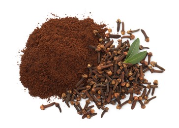 Pile of clove powder, dried buds and green leaves on white background, top view. Aromatic spice