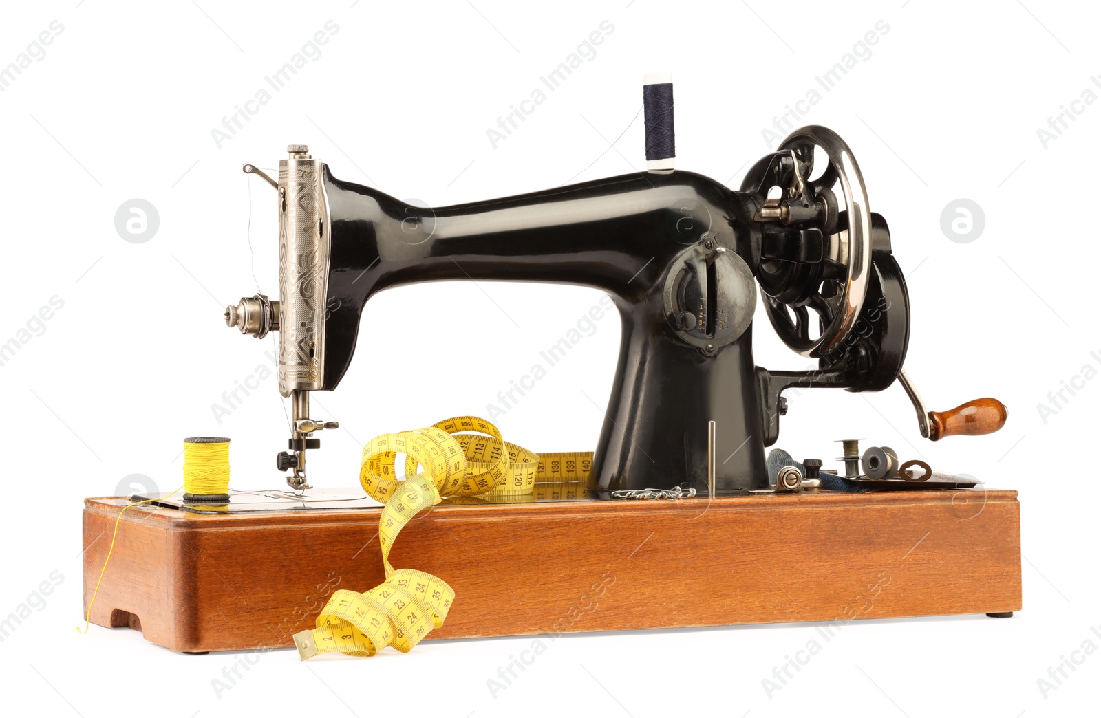 Photo of Sewing machine, measuring tape, safety pins and spools of threads isolated on white