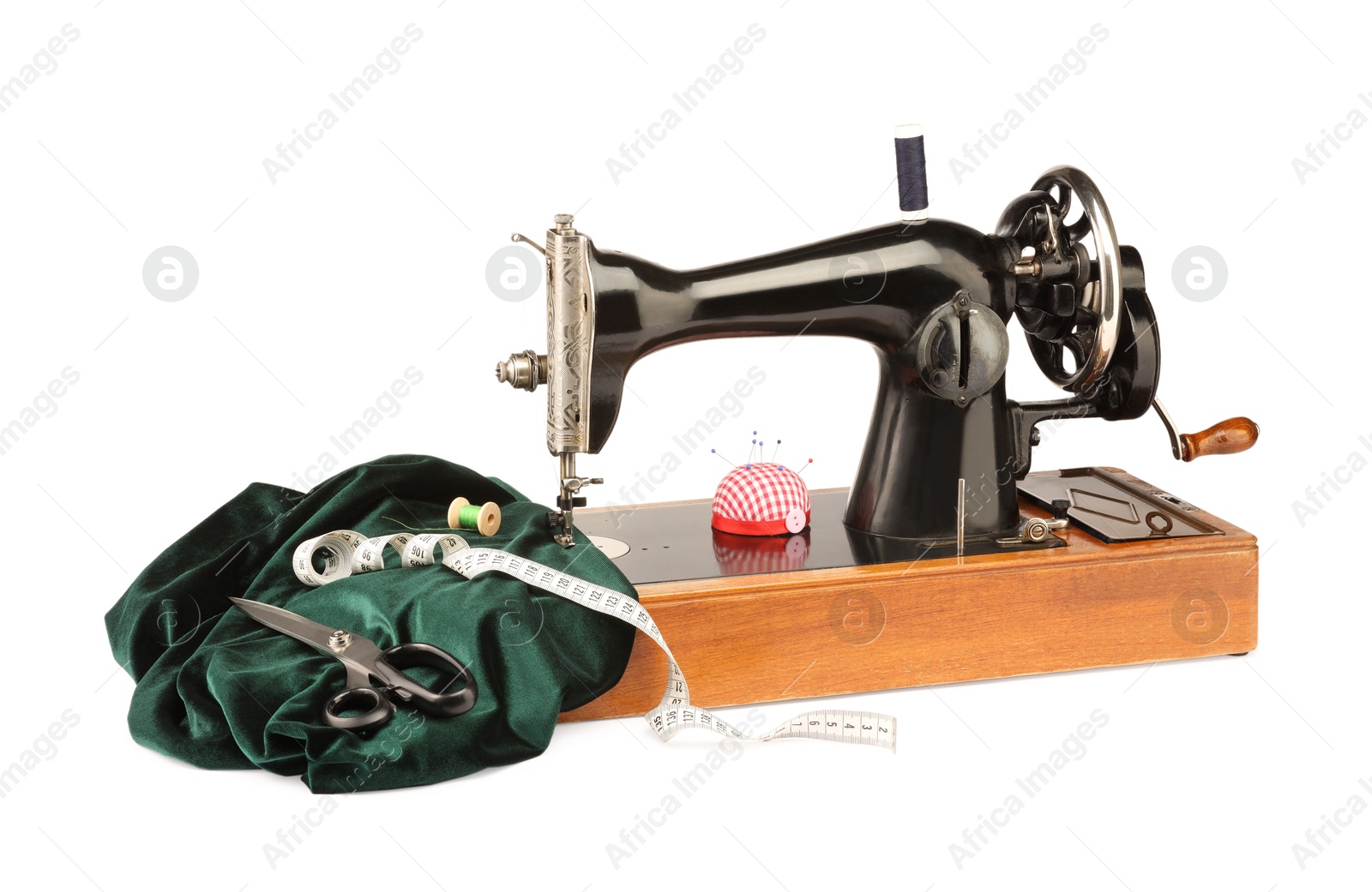 Photo of Sewing machine with green fabric and other supplies isolated on white