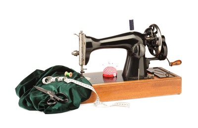 Photo of Sewing machine with green fabric and other supplies isolated on white