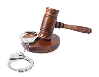 Handcuffs and judge's gavel isolated on white