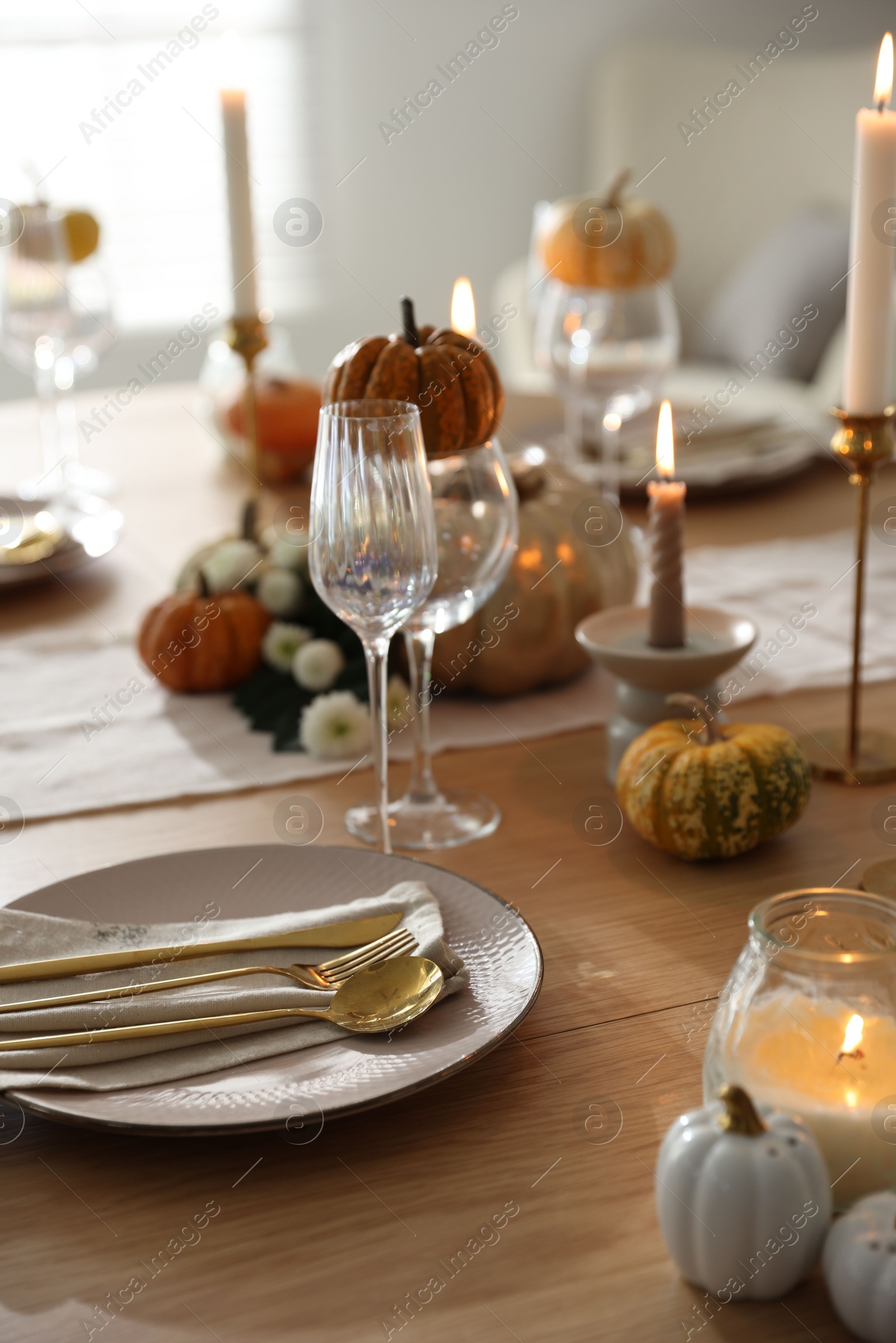 Photo of Stylish table setting with beautiful dishware, glasses and autumn decor in dining room