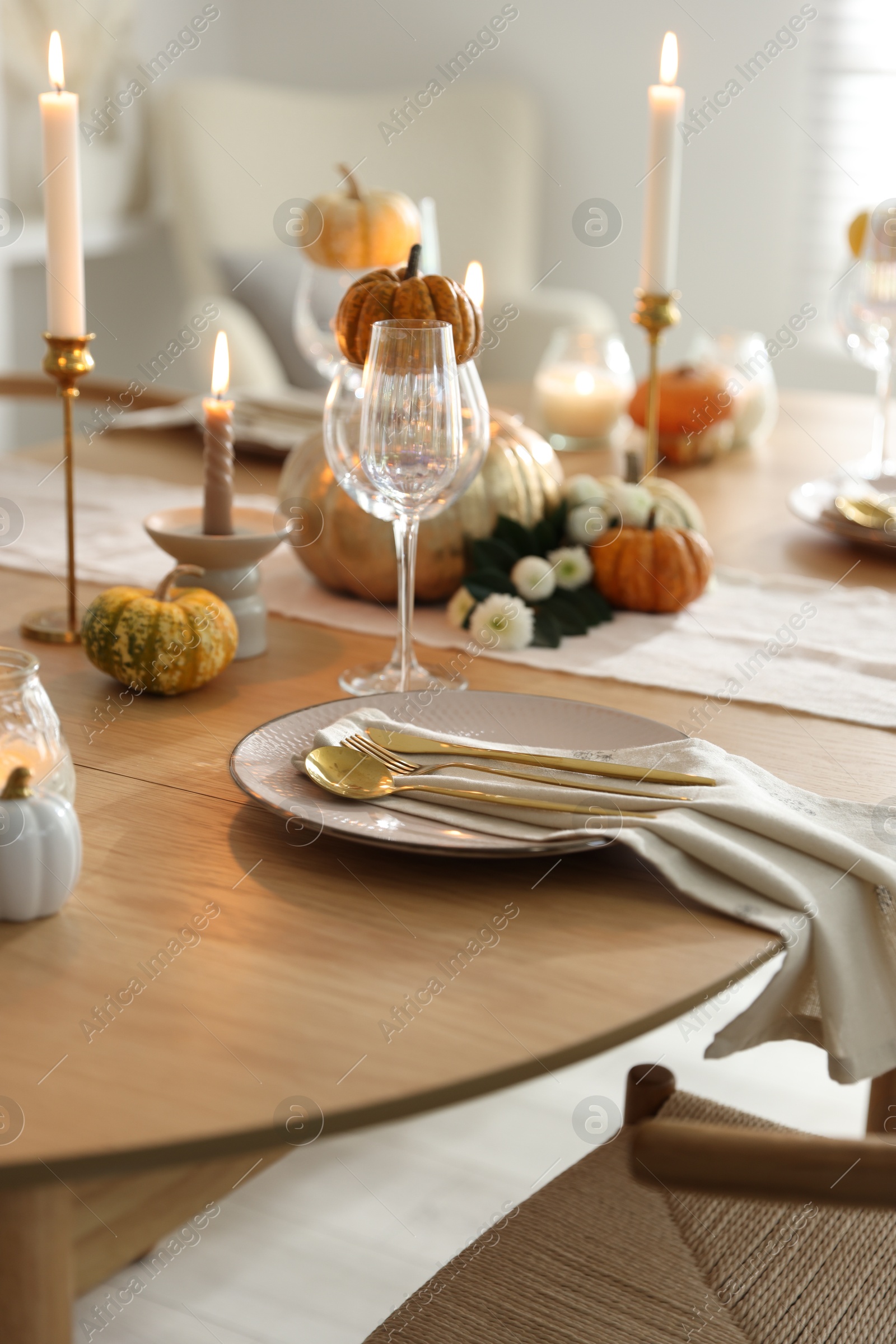 Photo of Stylish table setting with beautiful dishware, glasses and autumn decor in dining room