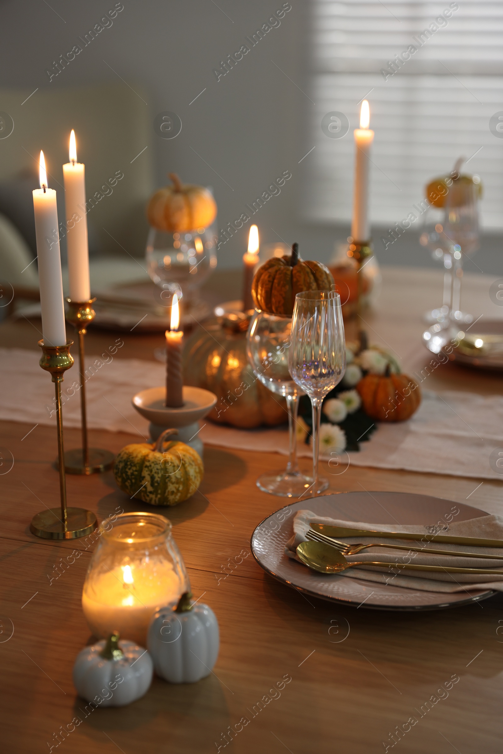 Photo of Stylish table setting with beautiful dishware, glasses and autumn decor in dining room