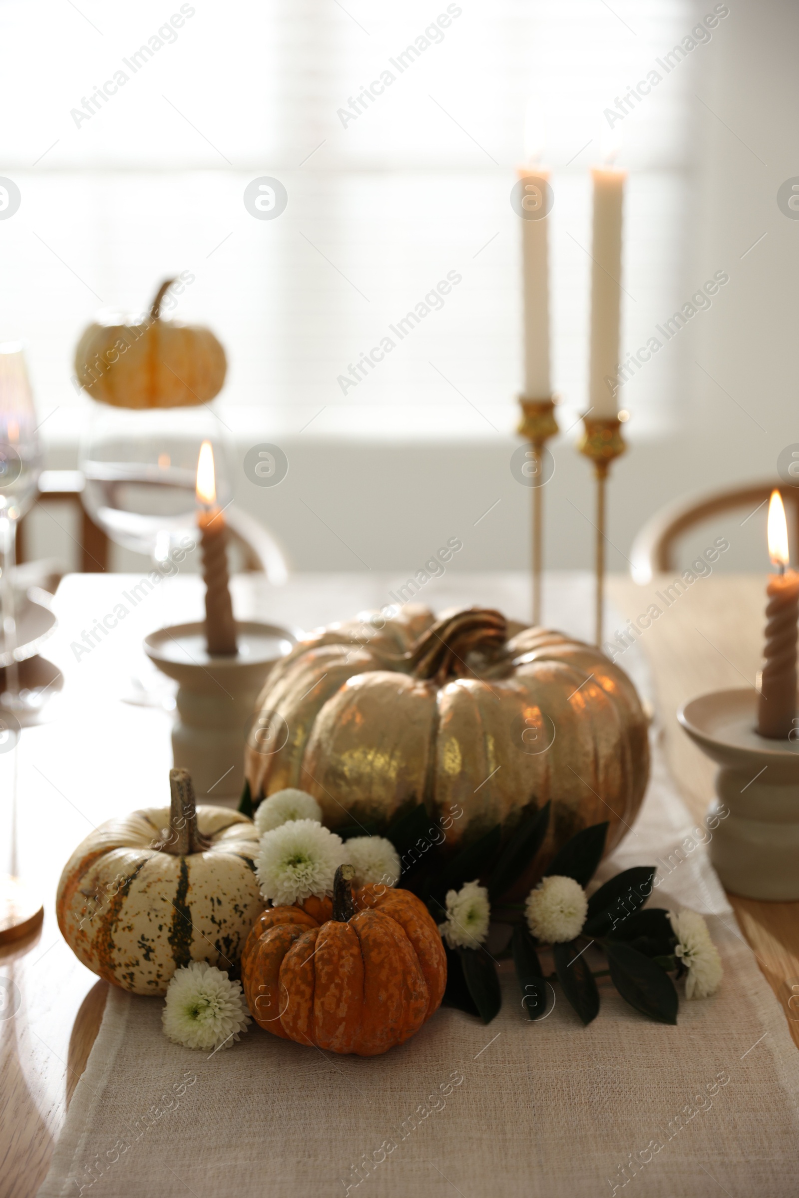 Photo of Stylish table setting with candles and autumn decor in dining room