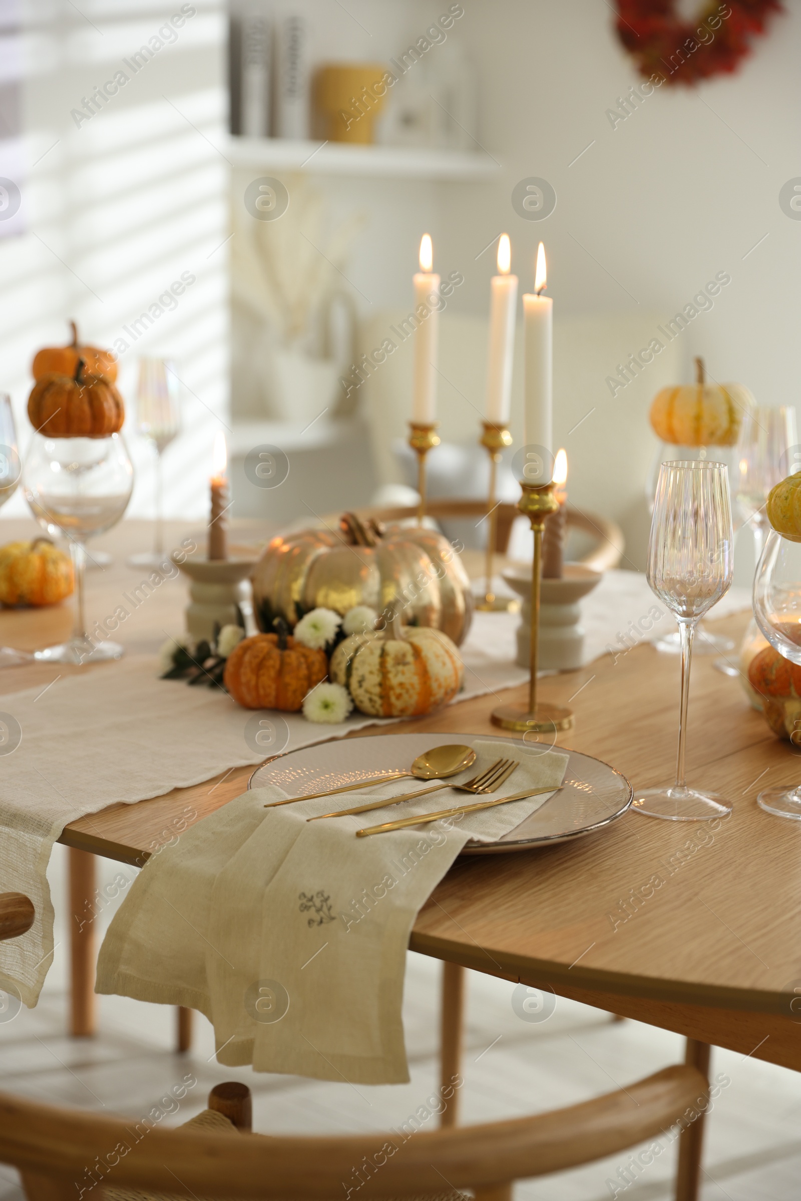 Photo of Stylish table setting with beautiful dishware, glasses and autumn decor in dining room