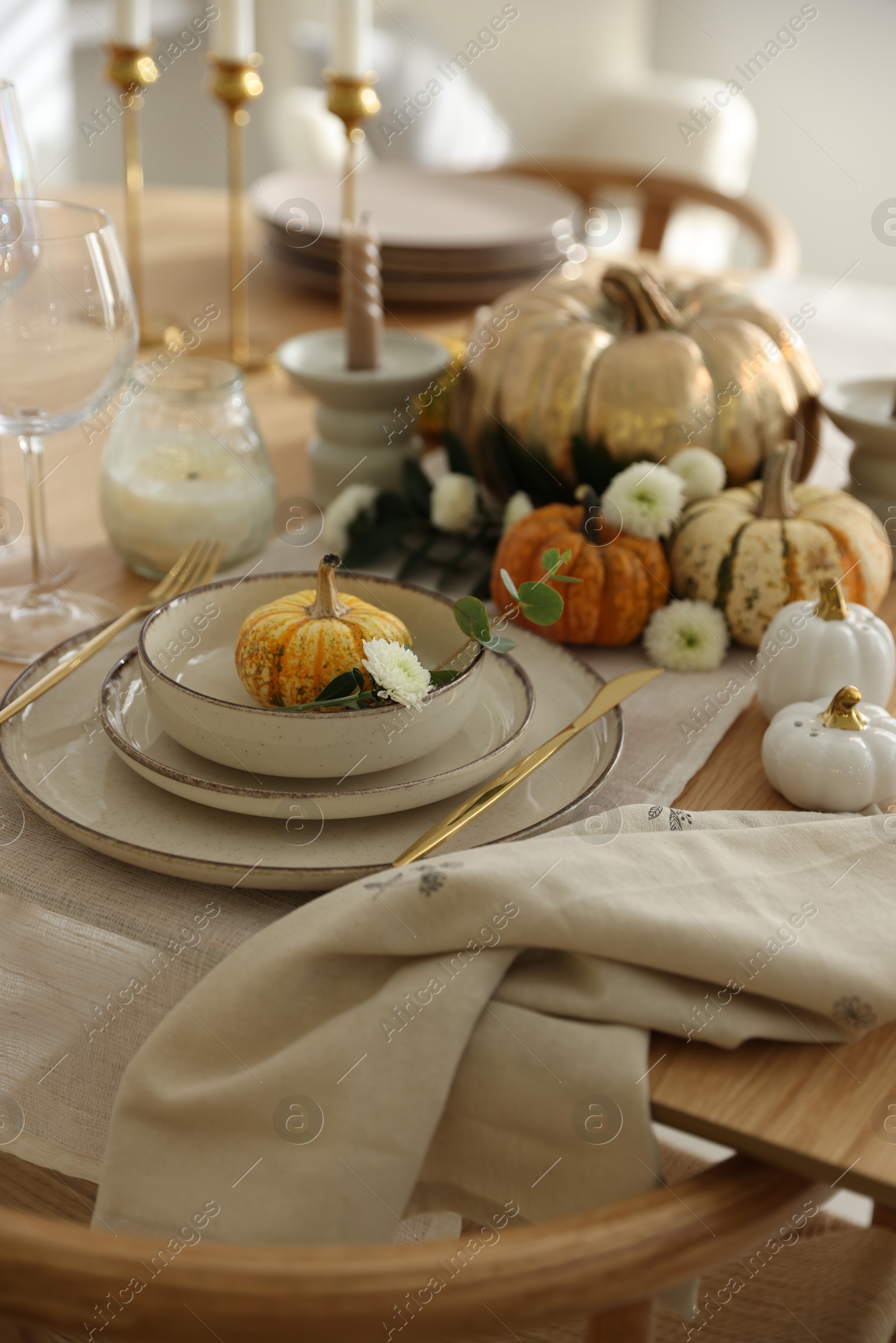 Photo of Stylish table setting with beautiful dishware and autumn decor in dining room