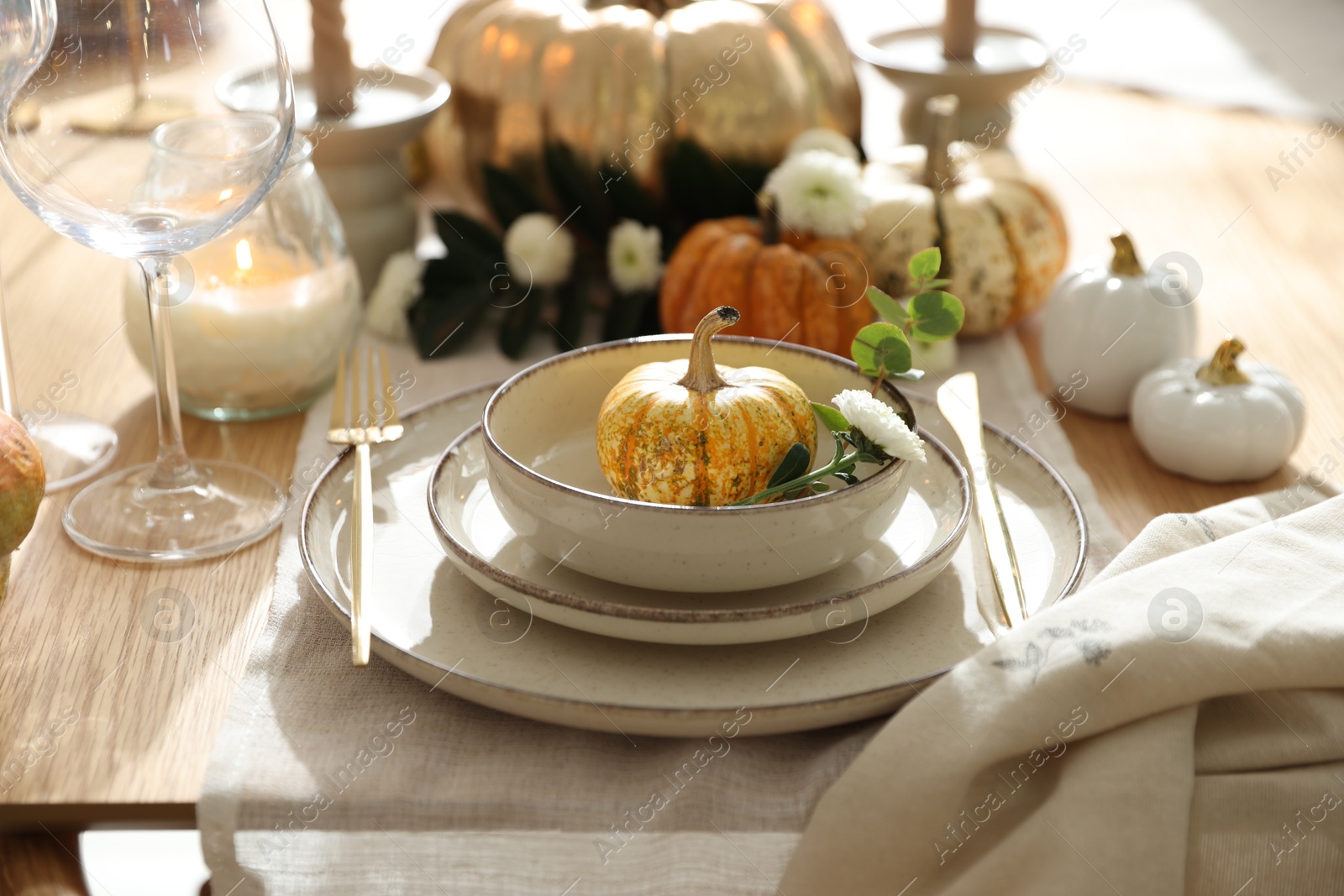 Photo of Stylish table setting with beautiful dishware and autumn decor in dining room