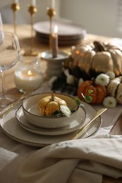 Stylish table setting with beautiful dishware and autumn decor in dining room