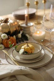 Stylish table setting with beautiful dishware and autumn decor in dining room