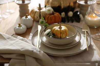 Photo of Stylish table setting with beautiful dishware and autumn decor in dining room