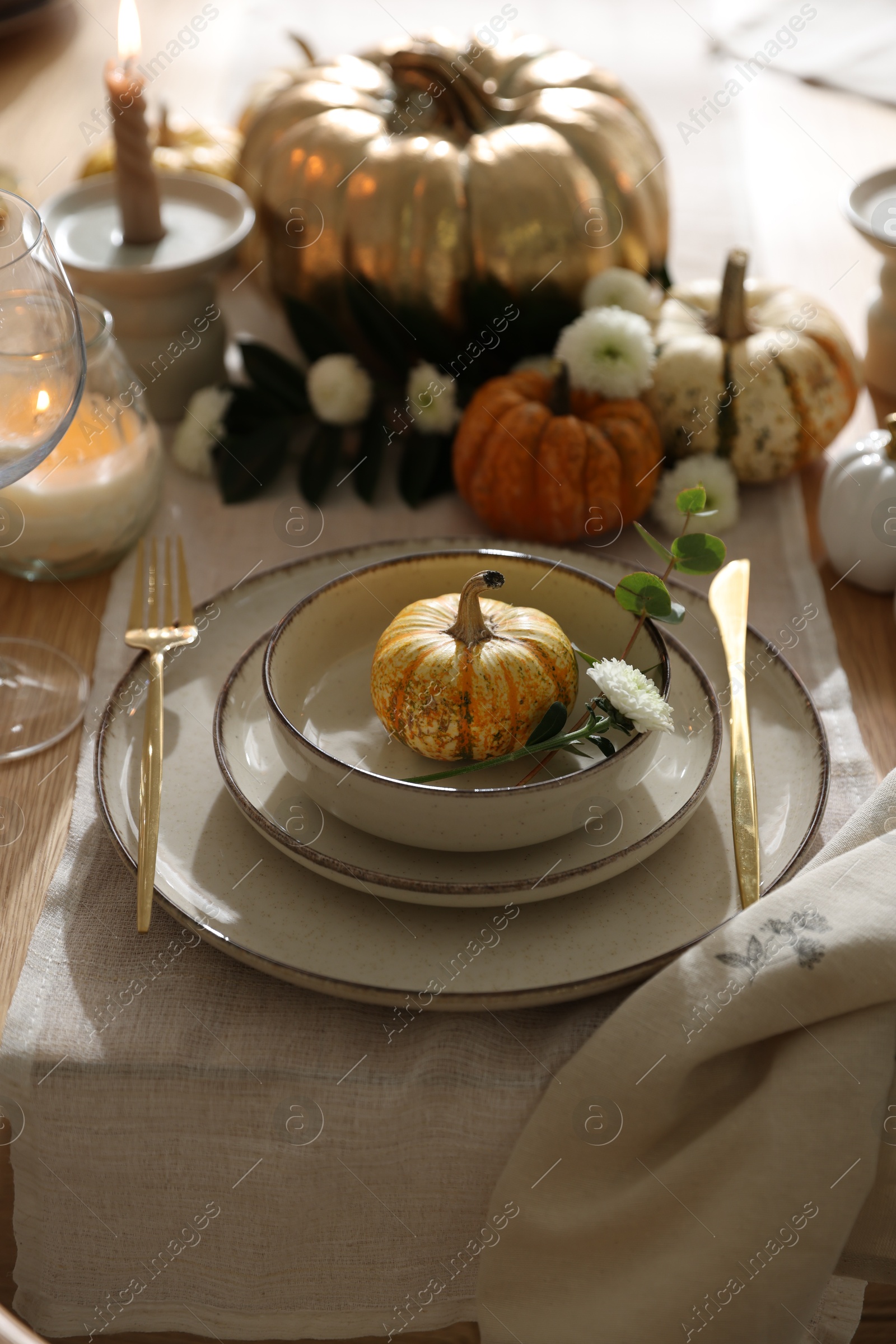 Photo of Stylish table setting with beautiful dishware and autumn decor in dining room