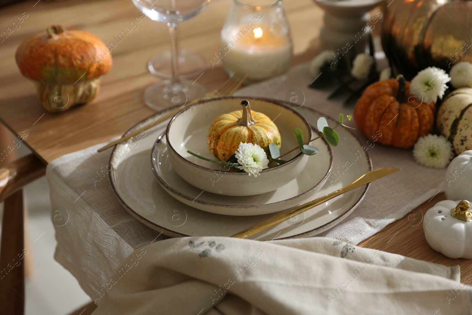 Photo of Stylish table setting with beautiful dishware and autumn decor in dining room