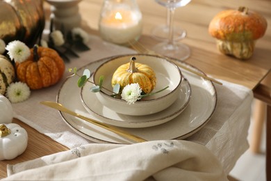 Photo of Stylish table setting with beautiful dishware and autumn decor in dining room