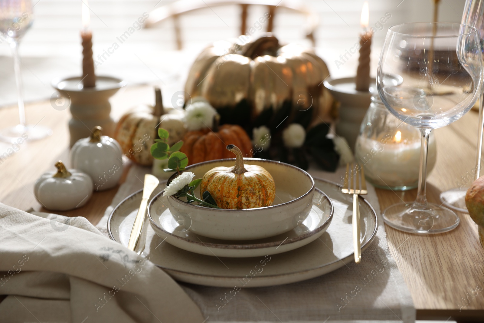 Photo of Stylish table setting with beautiful dishware, glasses and autumn decor in dining room