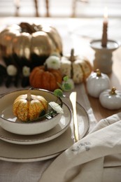 Stylish table setting with beautiful dishware and autumn decor in dining room