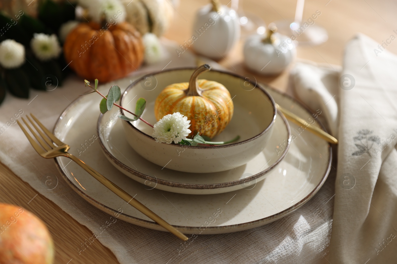 Photo of Stylish table setting with beautiful dishware and autumn decor in dining room, closeup