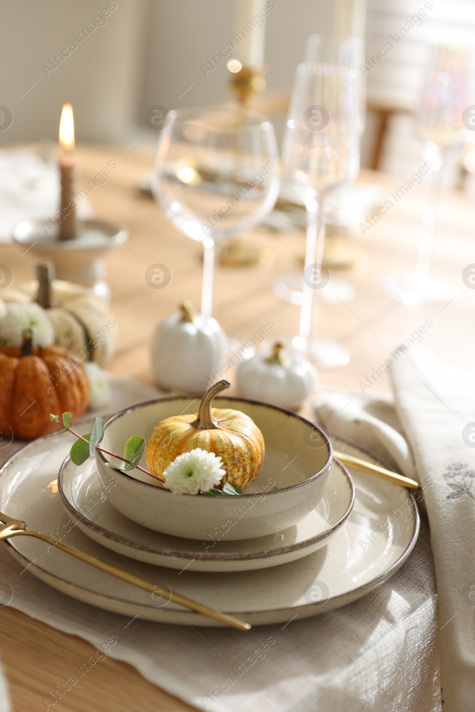 Photo of Stylish table setting with beautiful dishware, glasses and autumn decor in dining room