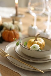 Photo of Stylish table setting with beautiful dishware and autumn decor in dining room, closeup