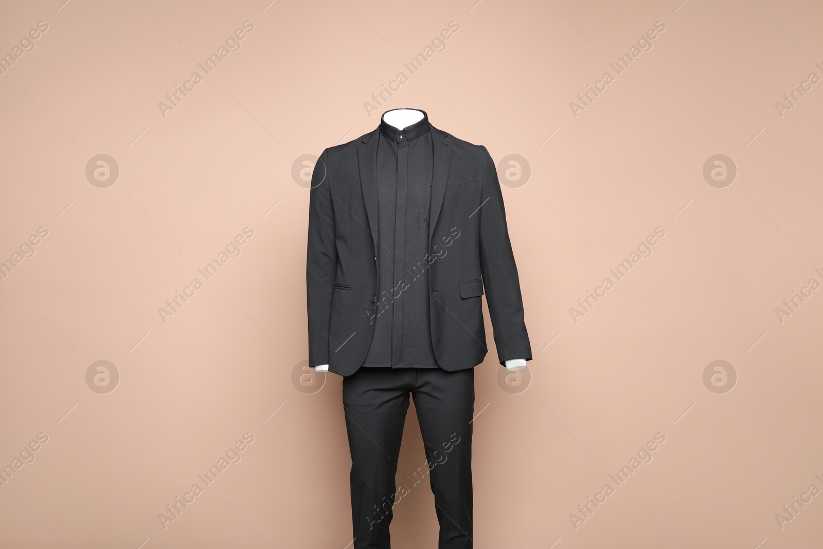 Photo of Male mannequin with stylish black suit on light brown background