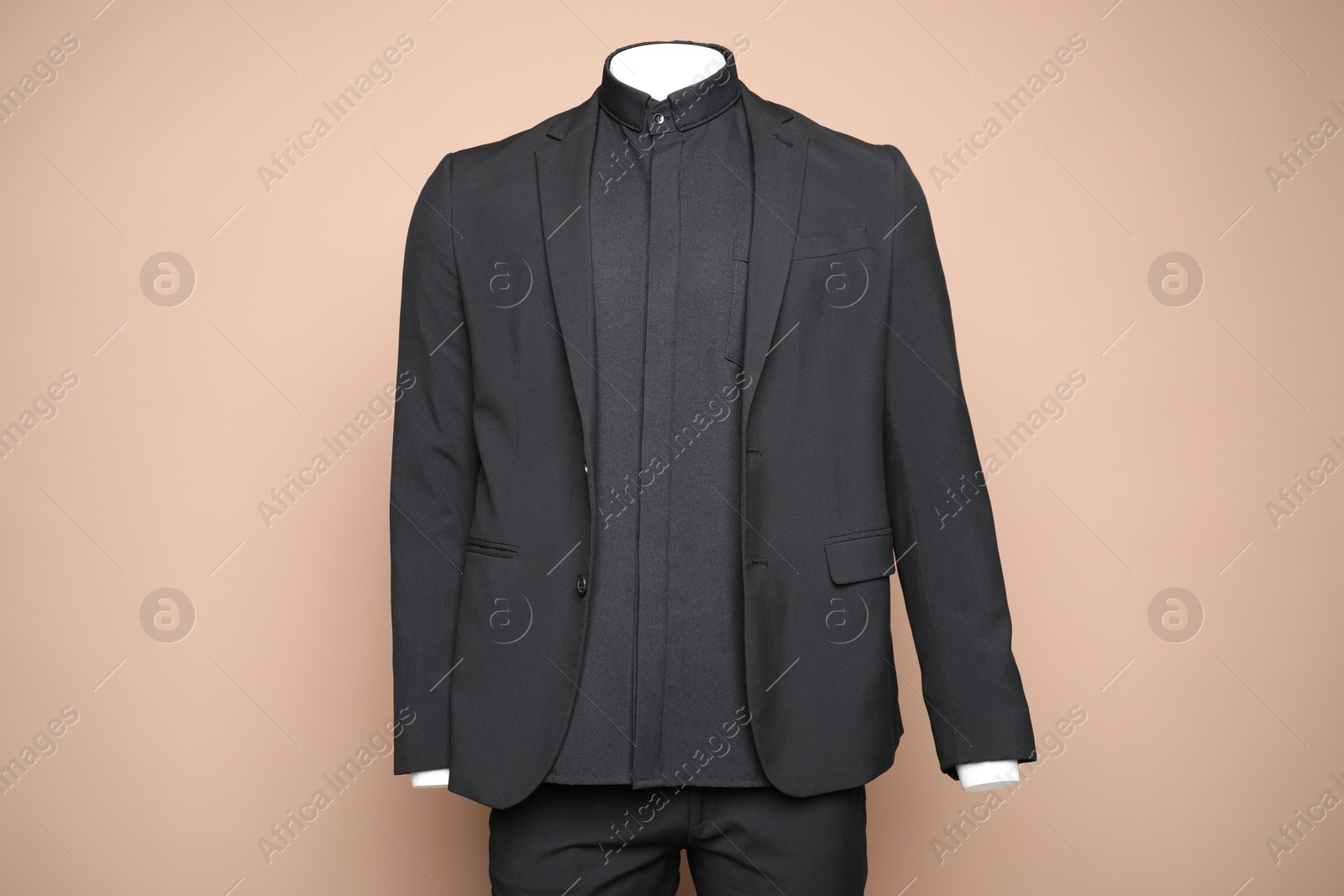 Photo of Male mannequin with stylish black suit on light brown background