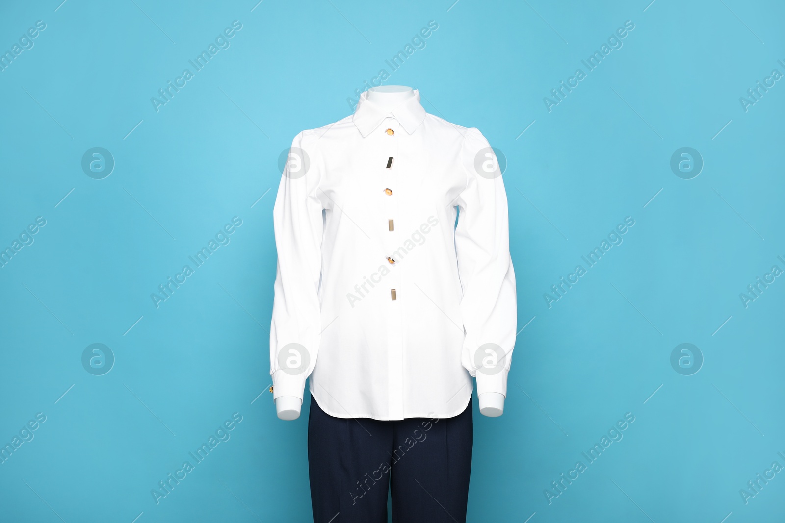 Photo of Female mannequin with stylish shirt and pants on light blue background