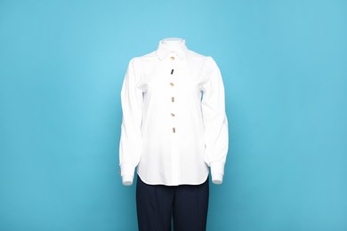 Photo of Female mannequin with stylish shirt and pants on light blue background