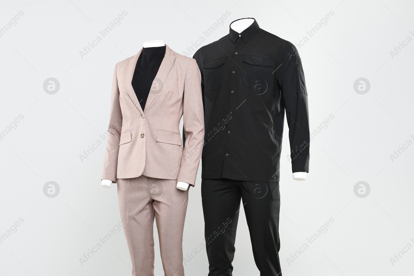 Photo of Female and male mannequins with stylish outfits on light background