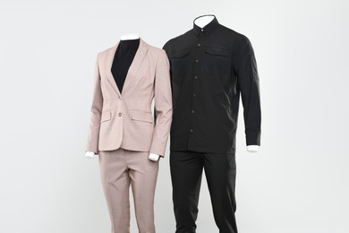 Photo of Female and male mannequins with stylish outfits on light background