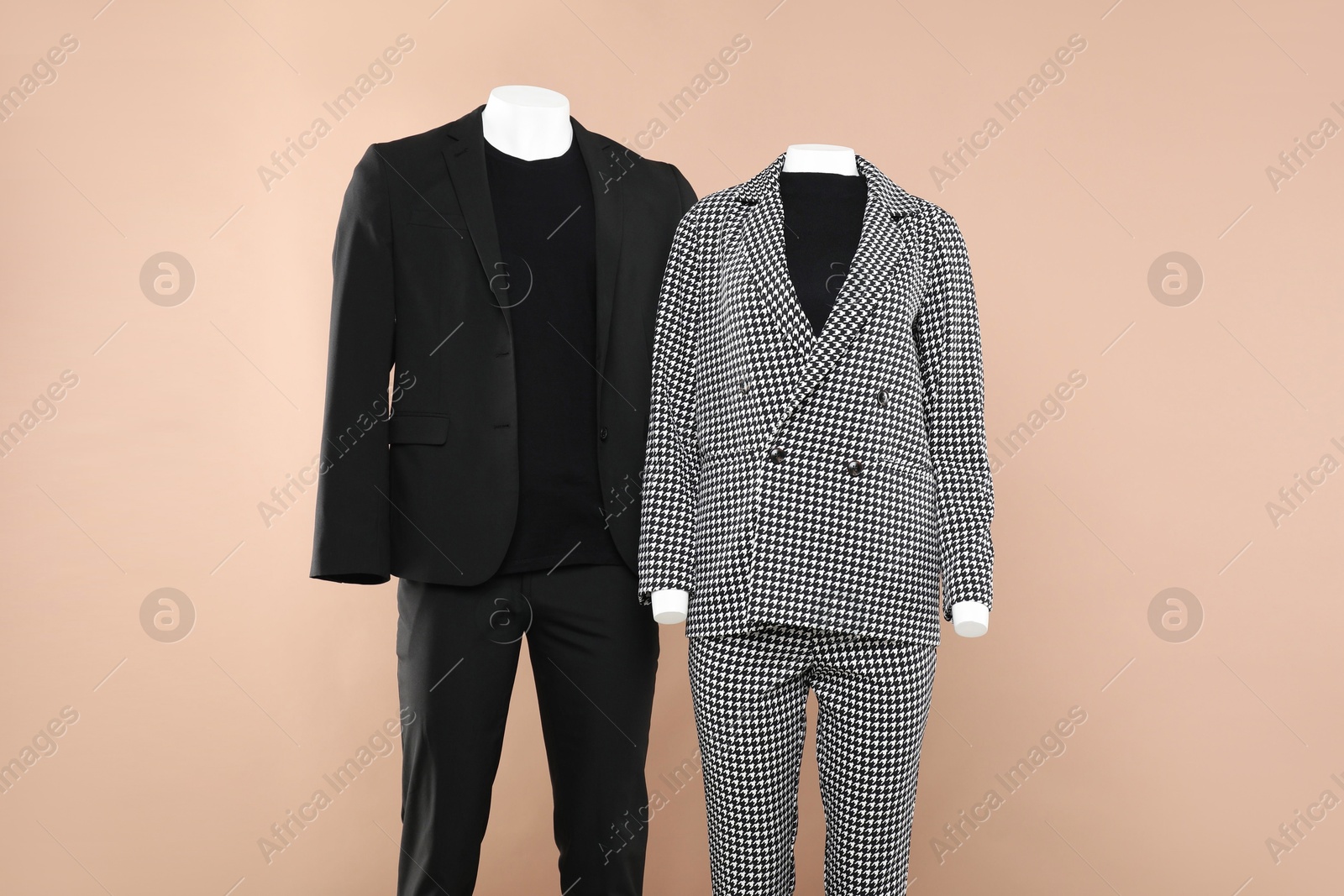 Photo of Female and male mannequins with stylish outfits on beige background